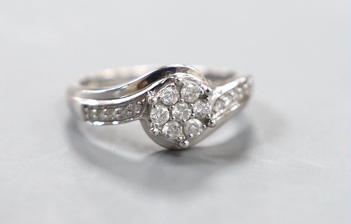 A modern 18kt white metal and diamond cluster set ring, size P, gross weight 3.8 grams.
